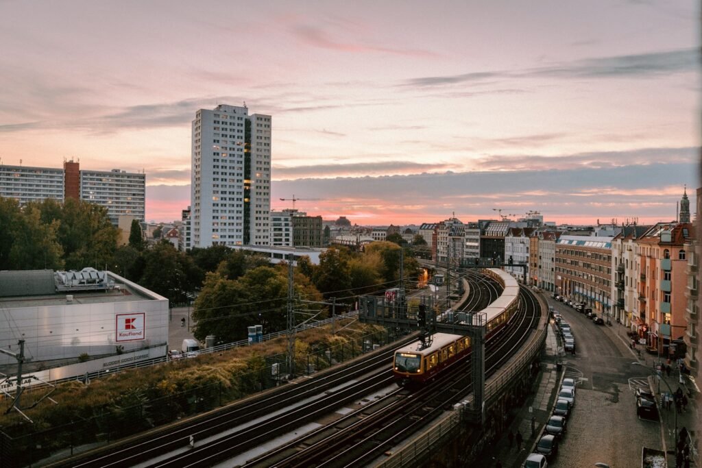 a train traveling down train tracks next to tall buildings