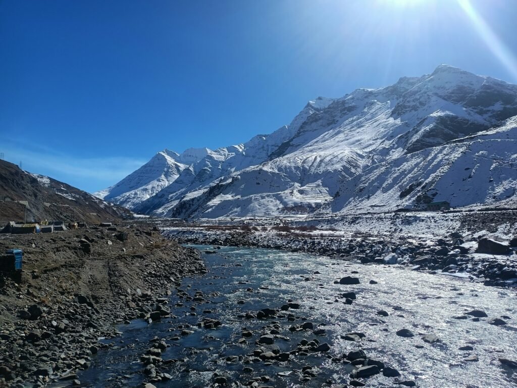 the sun shines brightly on the snowy mountains