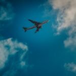 white airplane under blue and white cloudy sky