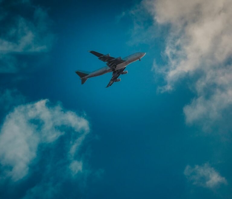 white airplane under blue and white cloudy sky