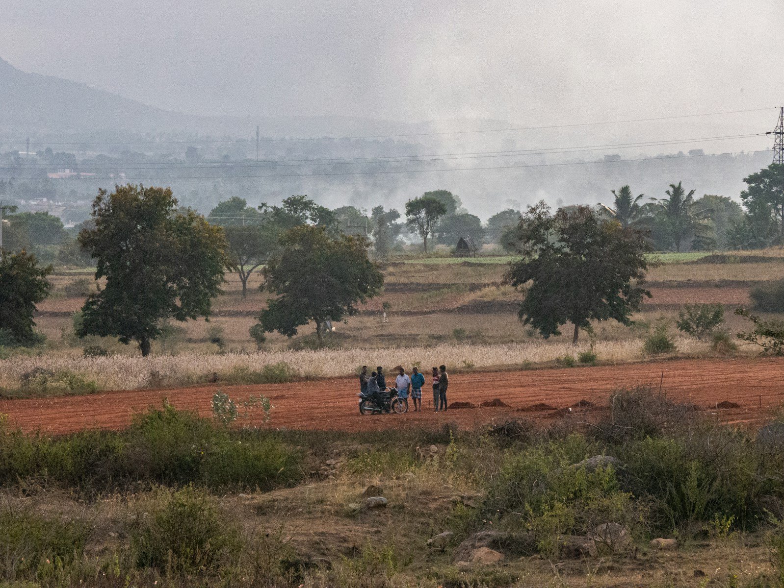 a group of people standing on a dirt road