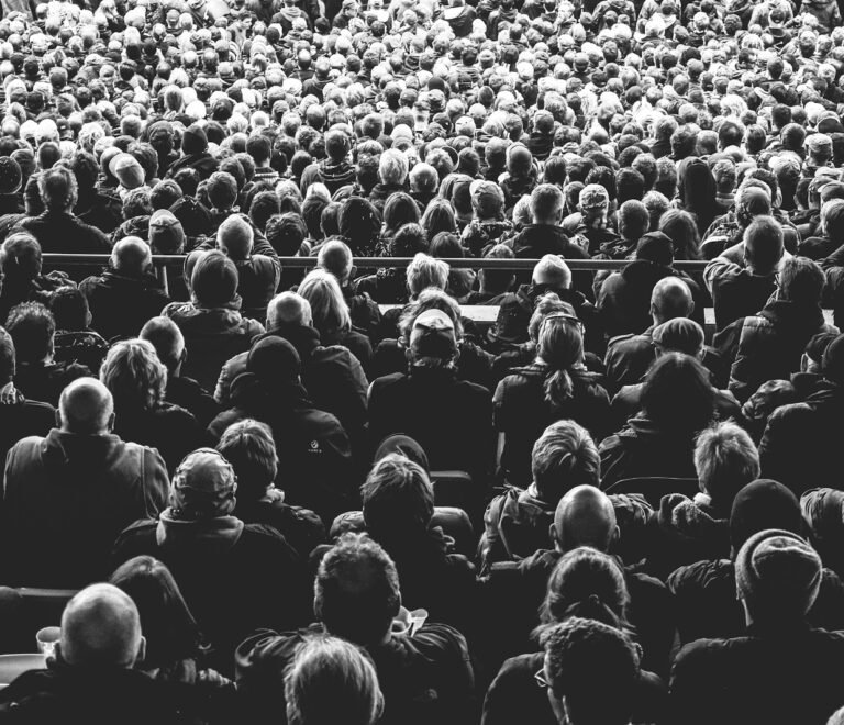 grayscale photo of people sitting on chair