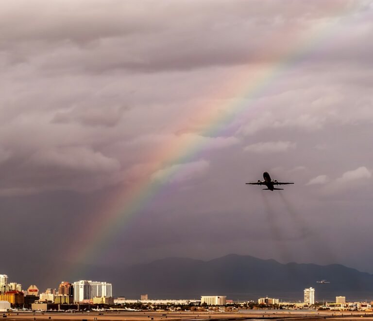 a plane flying in the sky with a rainbow in the background