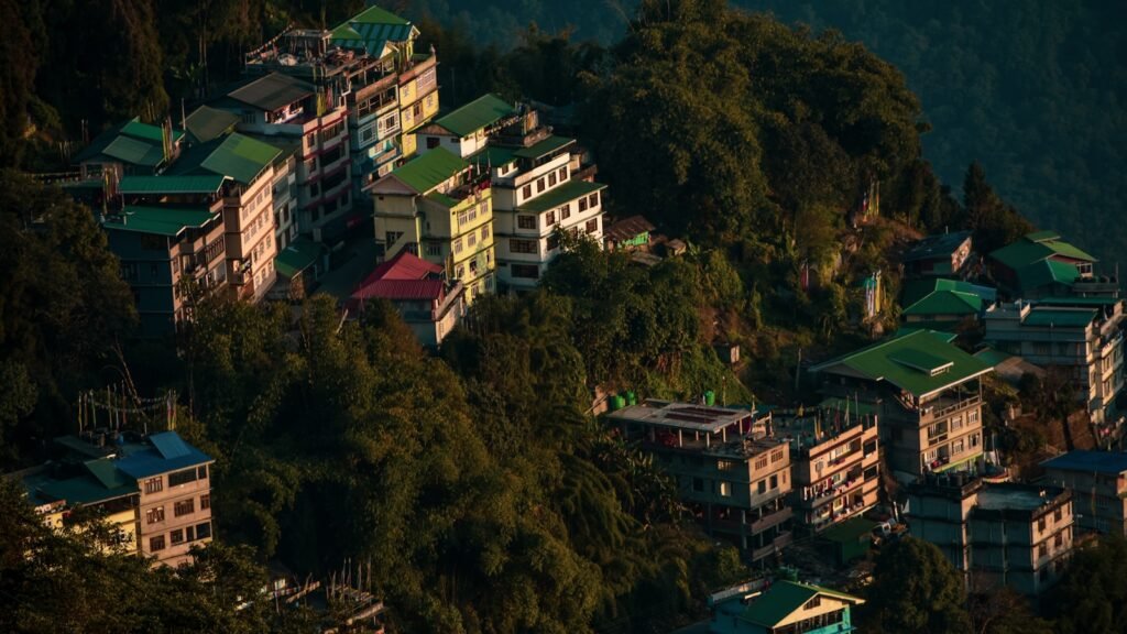 white and red concrete building on green mountain during daytime