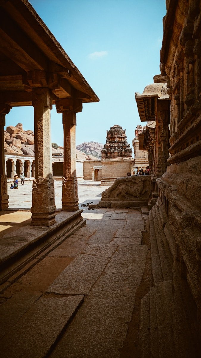 a stone building with pillars and a clock tower in the background