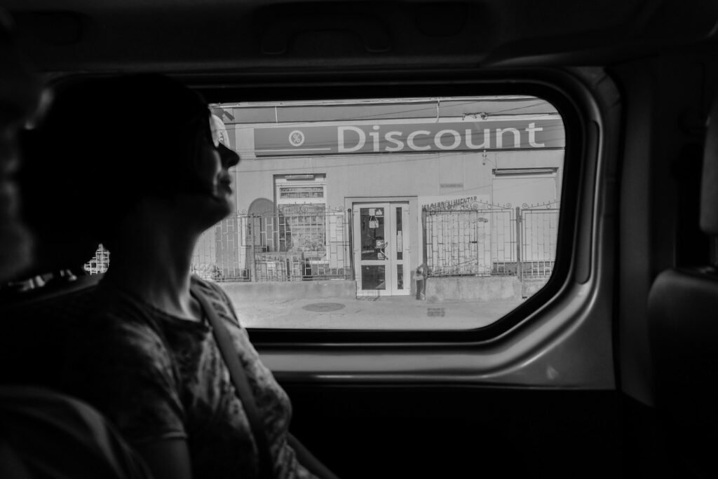 greyscale photography of woman inside vehicle