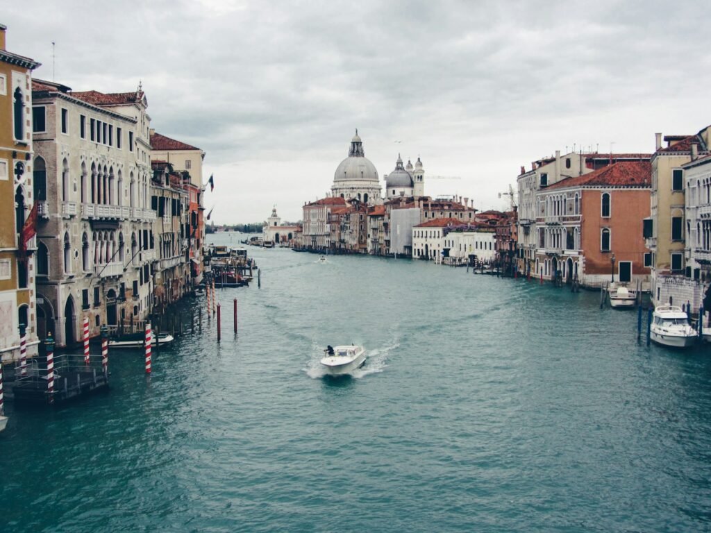 a boat traveling down a river next to tall buildings