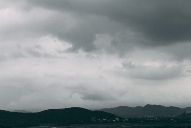 white boat on sea under gray clouds